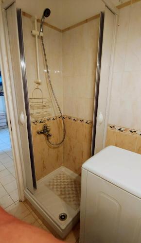 une douche avec une porte vitrée dans une salle de bain dans l'établissement GLORIADALI’, à Antibes