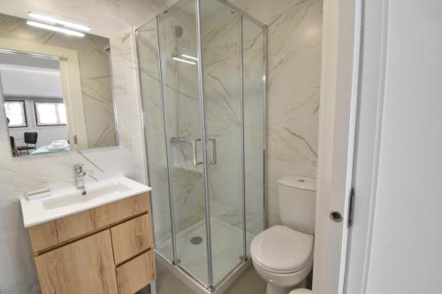 a bathroom with a shower and a toilet and a sink at Sophia Studios in Coimbra