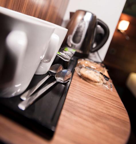 a table with a cup and a plate of food at Best Western Plus Lancashire Manor Hotel in Skelmersdale
