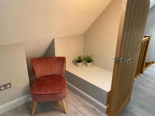 a room with a chair and two plants on a shelf at Oak Bray Coach House in Bray