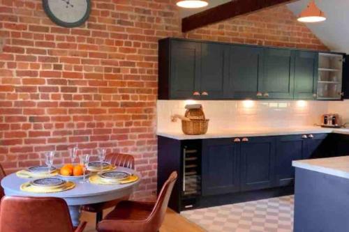 a kitchen with a table and a brick wall at Hayes Suite in Oswestry
