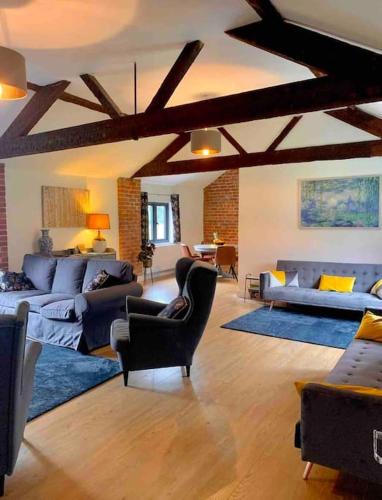 a living room with couches and chairs in a building at Hayes Suite in Oswestry