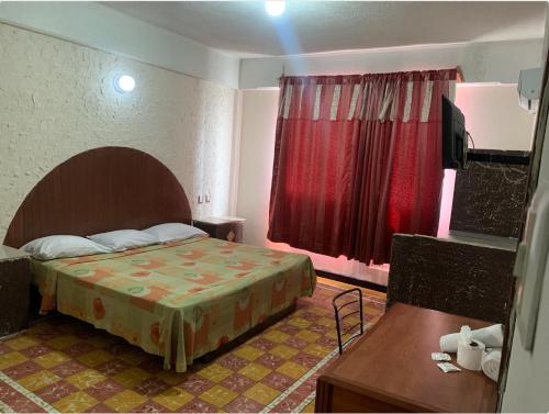 Habitación de hotel con cama y ventana roja en Hotel Papagayo Veracruz, en Veracruz