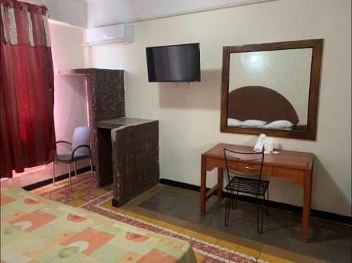 a room with a desk and a mirror and a bed at Hotel Papagayo Veracruz in Veracruz