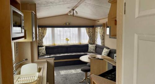 a caravan living room with a couch and a table at dees caravan lettings kingfisher elm 453 in Ingoldmells