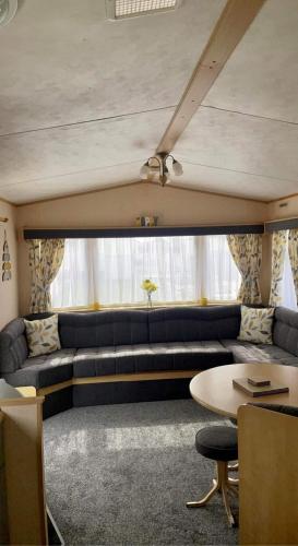 a living room with a couch and a table at dees caravan lettings kingfisher elm 453 in Ingoldmells