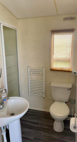 a bathroom with a toilet and a sink at dees caravan lettings kingfisher elm 453 in Ingoldmells