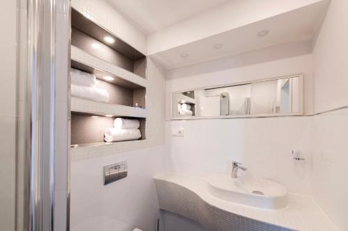 a white bathroom with a sink and a mirror at Tor Hotel in Nideggen