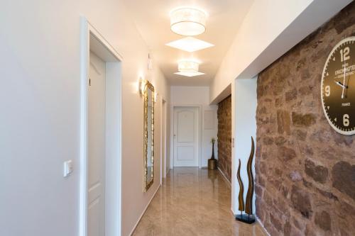 a hallway with a stone wall and a clock on a wall at Tor Hotel in Nideggen