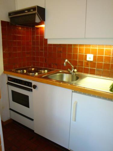 a kitchen with a sink and a stove at Apartment Grand Vallon in Grimentz