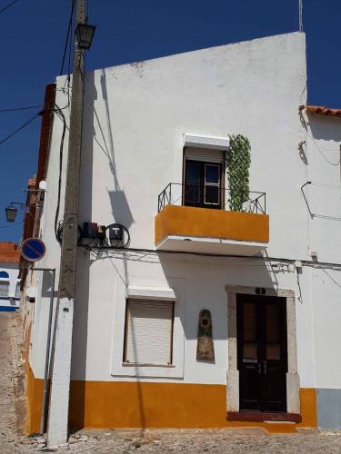 a white building with a window and a balcony at Casa Girassol in Santiago do Cacém