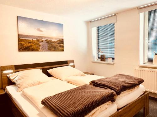 two beds in a bedroom with a painting on the wall at UsedomTor 1720 FeWo I in Wolgast