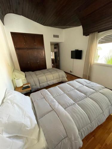 Un dormitorio con dos camas y un televisor de pantalla plana. en Arístides Lodge, en Mendoza