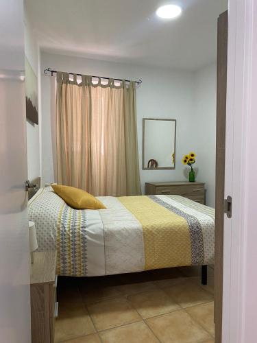 a bedroom with a bed with a yellow and white blanket at APARTAMENTO ARACENA RURAL in Aracena