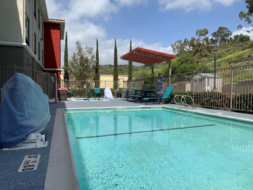 a large swimming pool with a picnic table and a table at Holiday Inn Express & Suites - Lake Forest, an IHG Hotel in Lake Forest