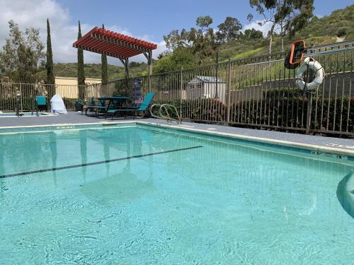 an empty swimming pool with a fence and a table and chairs at Holiday Inn Express & Suites - Lake Forest by IHG in Lake Forest
