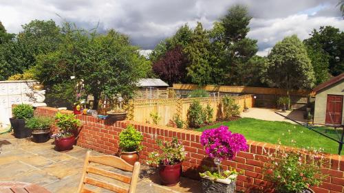 a garden with a brick wall with flowers and plants at Bay Tree House Bed & Breakfast in Barnet