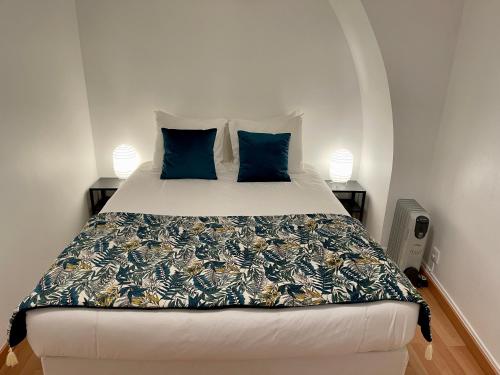 een slaapkamer met een groot bed met blauwe kussens bij Casa do Colégio Downtown Private Suite 57 in Ponta Delgada