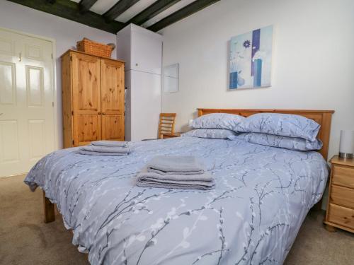 a bedroom with a bed with a blue comforter at The Granary in Great Driffield