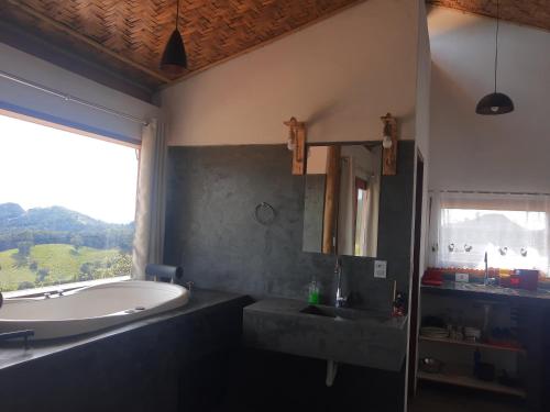 a bathroom with a bath tub and a sink at CASA NA MONTANHA in Gonçalves