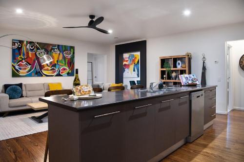 a kitchen with a sink and a living room at Manna Gums- beautiful secluded setting in Daylesford