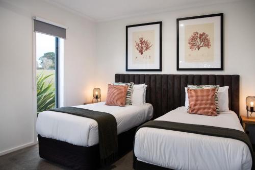 two beds in a room with a window at Manna Gums- beautiful secluded setting in Daylesford