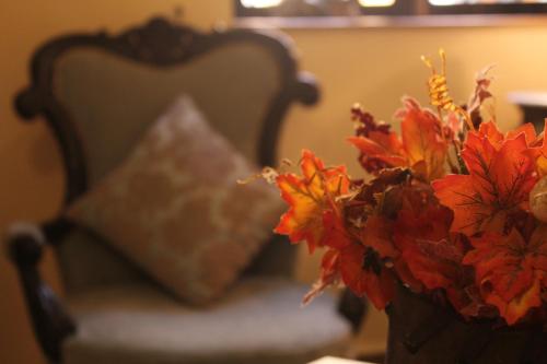 a vase with flowers in front of a chair at La Maison by Dia Hotels and Homes in Panaji