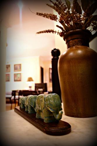 a vase and two statues of elephants on a table at La Maison by Dia Hotels and Homes in Panaji
