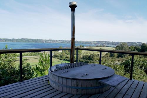 a table on a deck with a view of the water at Parcela Nueve in Frutillar