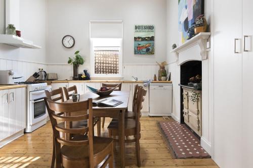 a kitchen with a table and chairs in a kitchen at Albert Cottage - charming miner's cottage in town in Daylesford
