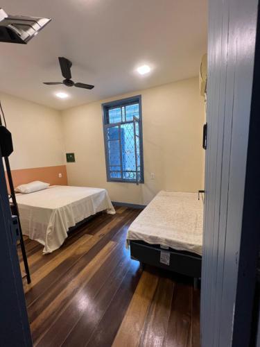a room with two beds and a ceiling fan at Hostel El Caminito LGBTQIAPN plus in Santos