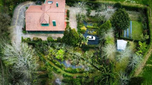a large green building with a clock on the side of it at Quinta de Santana - Queimadas in Furnas