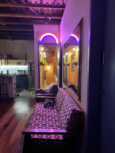a purple room with a couch and a mirror at Hostel El Caminito LGBTQIAPN plus in Santos