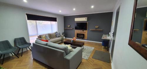 a living room with a couch and a table at Flamingo Rentals - Modern 2-bed unit with BBQ & SPA ideal for holiday and business travel in Mildura