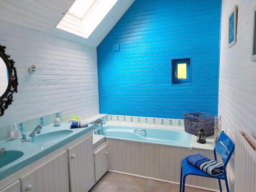 La salle de bains bleue est pourvue d'une baignoire et d'un lavabo. dans l'établissement Stone House in Portsall near Treompan Beach, à Ploudalmézeau