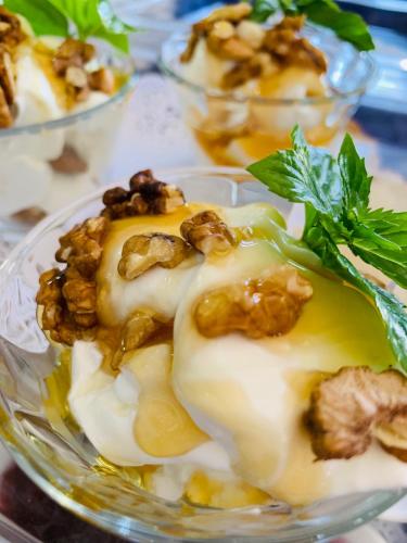 a glass bowl of food with nuts and a green garnishment at Arcana Santorini Villas, An Authentic Cycladic Experience in Akrotiri
