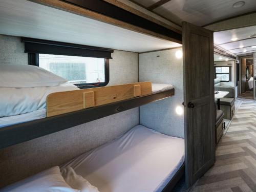 a small room with two bunk beds and a bathroom at Wood Pecker Nakijin in Nakijin
