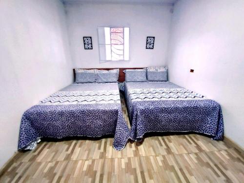 Duas camas num pequeno quarto com piso em madeira em Chácara Vale Por do Sol em Catimbau
