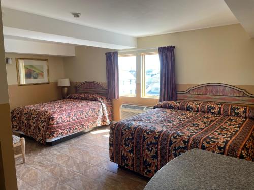 a hotel room with two beds and a window at Sea Palace Inn in Seaside Heights