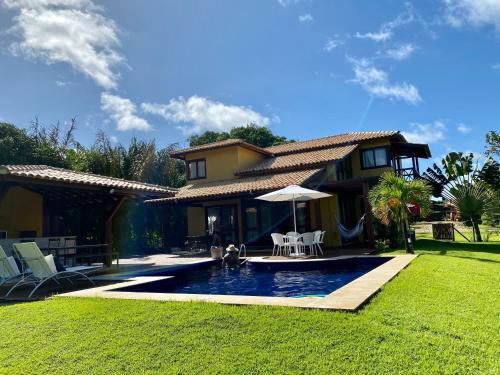 a house with a swimming pool in the yard at Costa do Sauipe Casa dentro do complexo hoteleiro in Costa do Sauipe