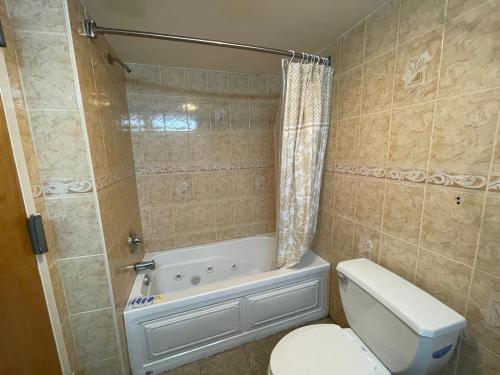 a bathroom with a tub and a toilet and a shower at Sea Palace Inn in Seaside Heights