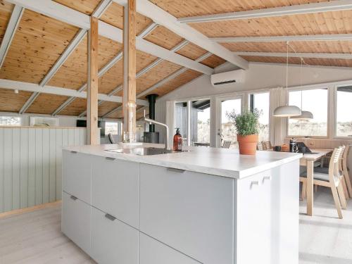 an open kitchen with white cabinets and a table at 6 person holiday home in Ålbæk-By Traum in Ålbæk