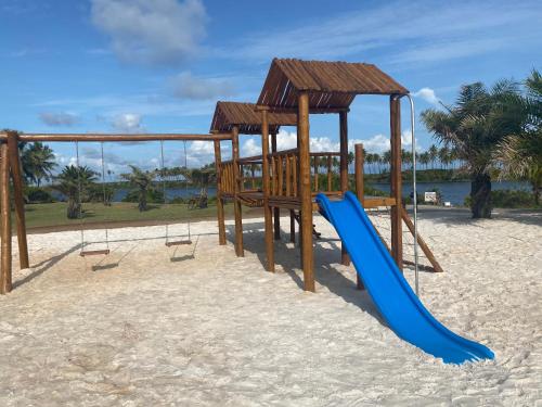a playground with a blue slide on the beach at Costa do Sauipe Casa dentro do complexo hoteleiro in Costa do Sauipe