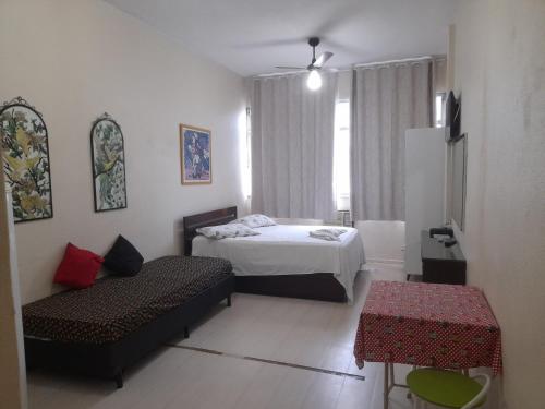 ein Schlafzimmer mit einem Bett, einem Sofa und einem Tisch in der Unterkunft santa clara 1003 in Rio de Janeiro