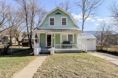 a small green house with a porch on a lawn at Lake Daze in Hammondsport