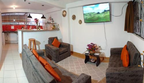 a living room with two couches and a kitchen at Runa Apartamentos in Cusco