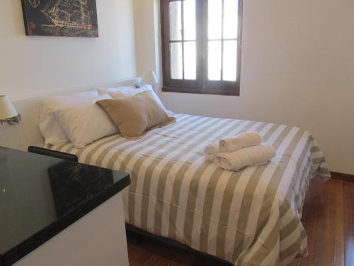 1 dormitorio con 1 cama con 2 toallas en Apartamento en el palacio salvo candombe, en Montevideo