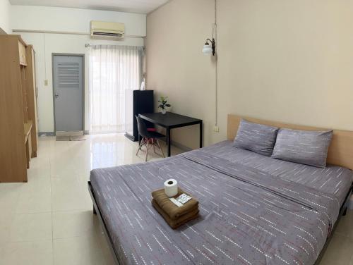 a bedroom with a bed and a desk in it at Grand Residence in Bangkok