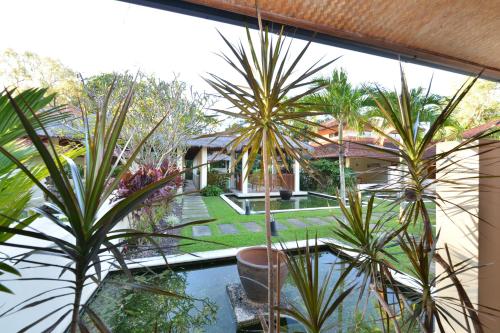 an indoor garden with palm trees and a swimming pool at Seascape Holidays Villa 8 Surya in Port Douglas
