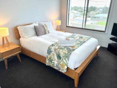 a bedroom with a bed and a large window at Bermagui Stays - Penthouse Apartment - Amazing Views & Location in Bermagui